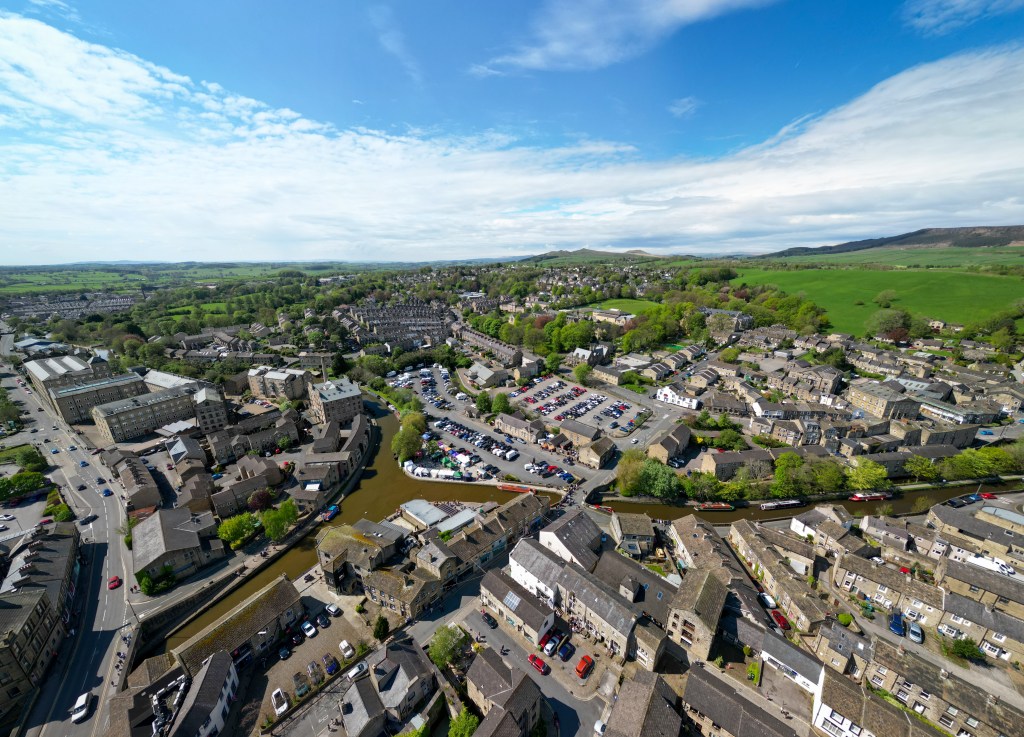 A wide-angle aerial image of a town in West Yorkshire. 